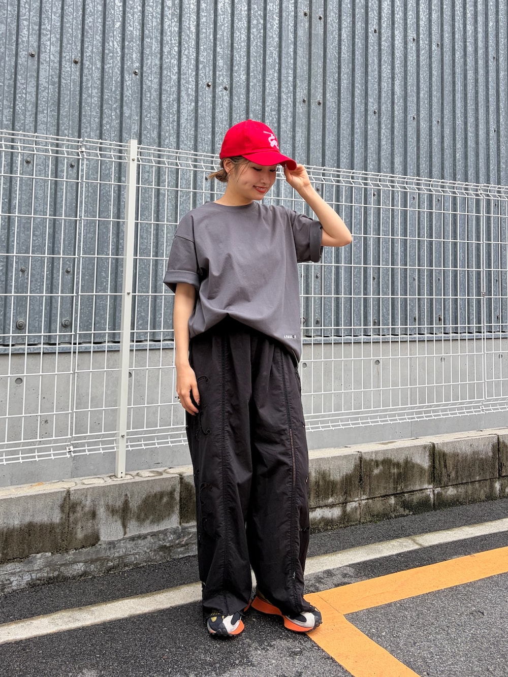 ブラック系のその他パンツ、グレー系のTシャツ/カットソー、レッド系のキャップを着用したレディースの夏コーディネートの2枚目の写真