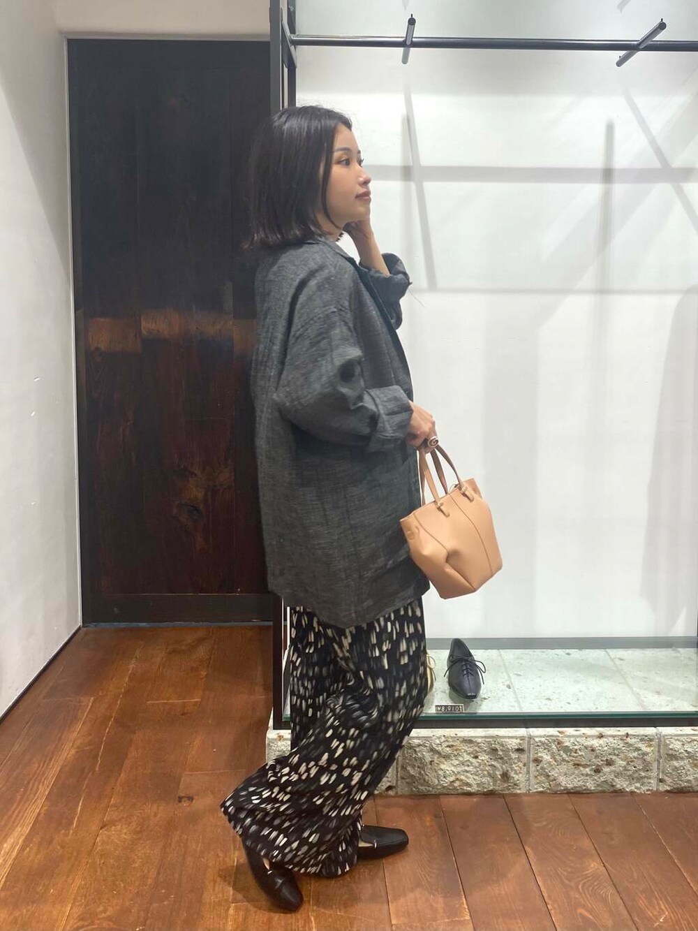 ブラック系のローファー、ホワイト系のタンクトップ、ベージュ系のショルダーバッグを着用したレディースの夏コーディネートの3枚目の写真