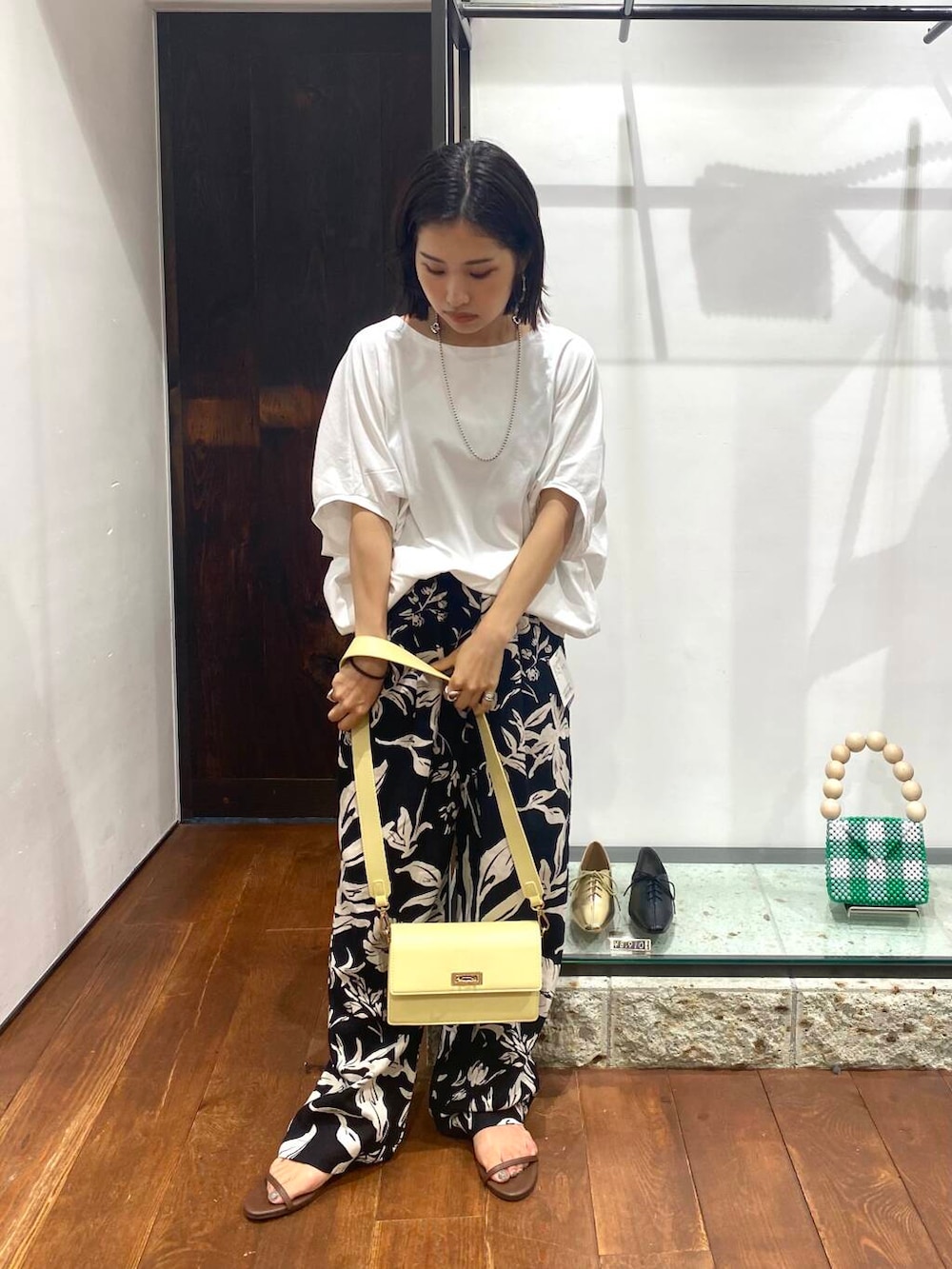 ブラック系のその他パンツ、ブラウン系のサンダル、ホワイト系のTシャツ/カットソーを着用したレディースの夏コーディネートの2枚目の写真