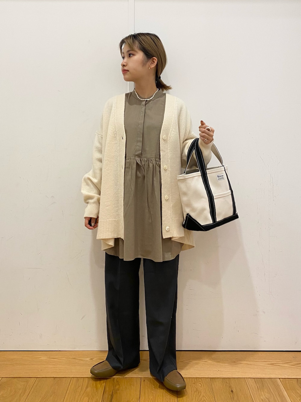 ホワイト系のカーディガン/ボレロ、グレー系のシャツ/ブラウス、グレー系のその他パンツを着用したレディースの冬コーディネートの2枚目の写真