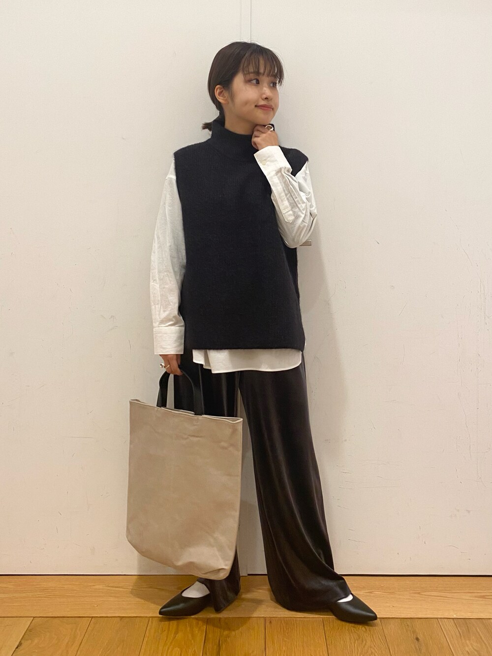 グレー系のその他パンツ、ブルー系のベスト、ホワイト系のシャツ/ブラウスを着用したレディースの冬コーディネートの3枚目の写真