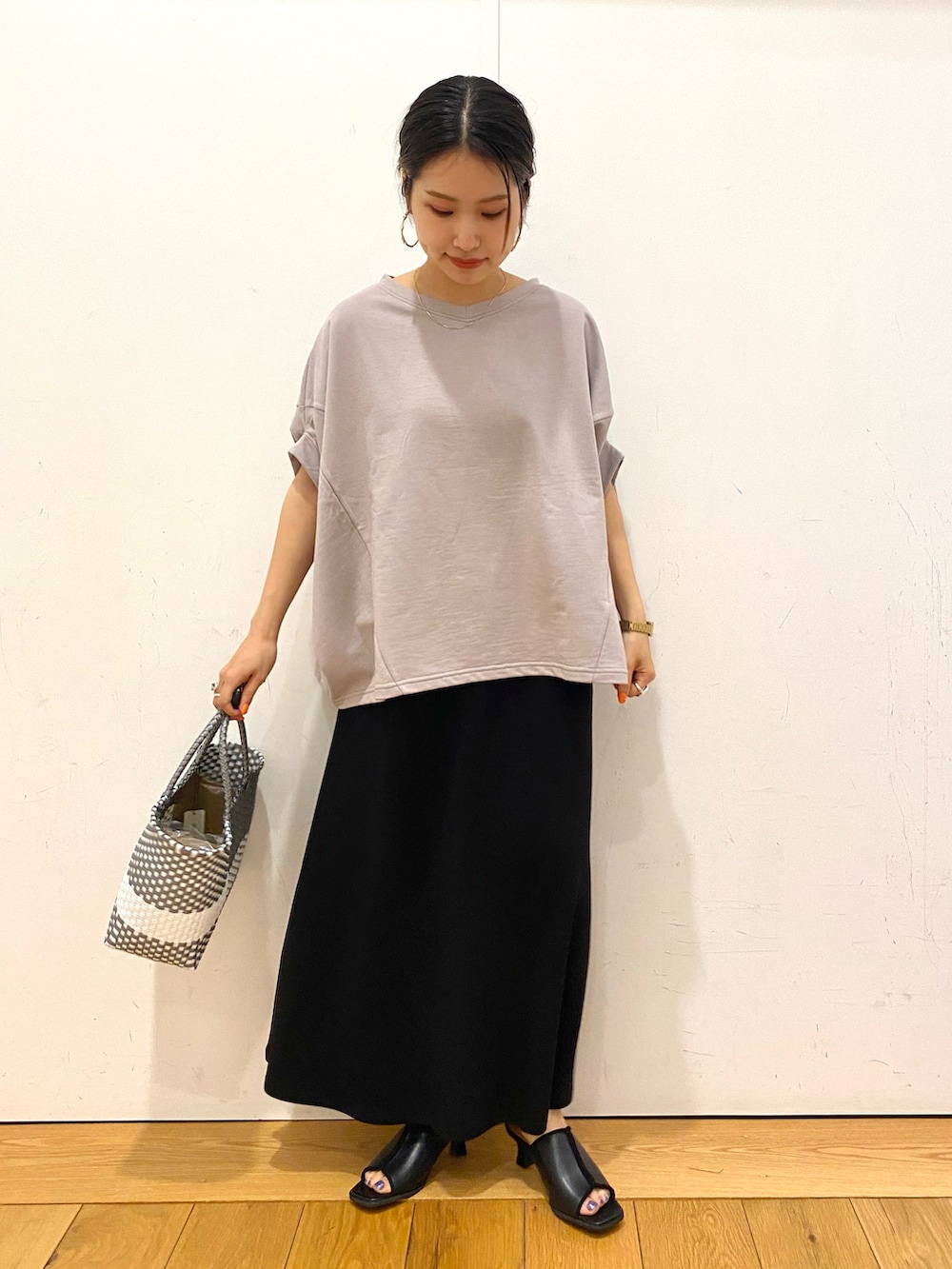 ベージュ系のTシャツ/カットソー、ブラック系のサンダル、シルバー系のトートバッグを着用したレディースの夏コーディネートの2枚目の写真