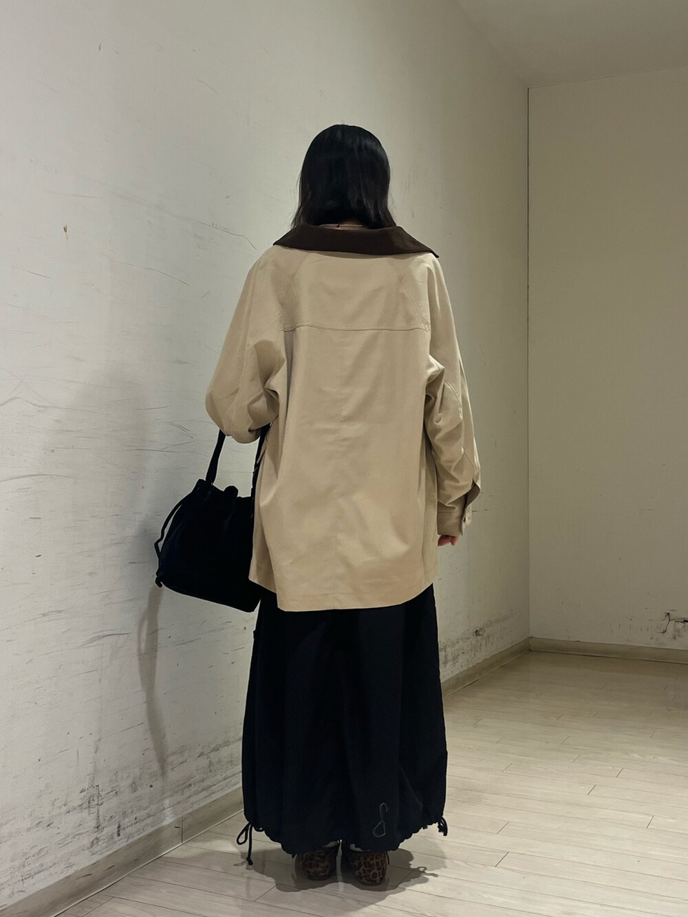 ベージュ系のブルゾン、ブルー系のTシャツ/カットソー、ブラック系のハンドバッグを着用したレディースの秋コーディネートの3枚目の写真