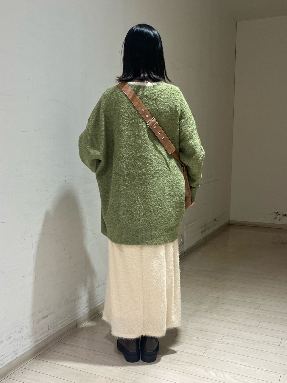 グリーン系のワンピース、イエロー系のハンドバッグ、ホワイト系のスカートを着用したレディースの秋コーディネートの2枚目の写真