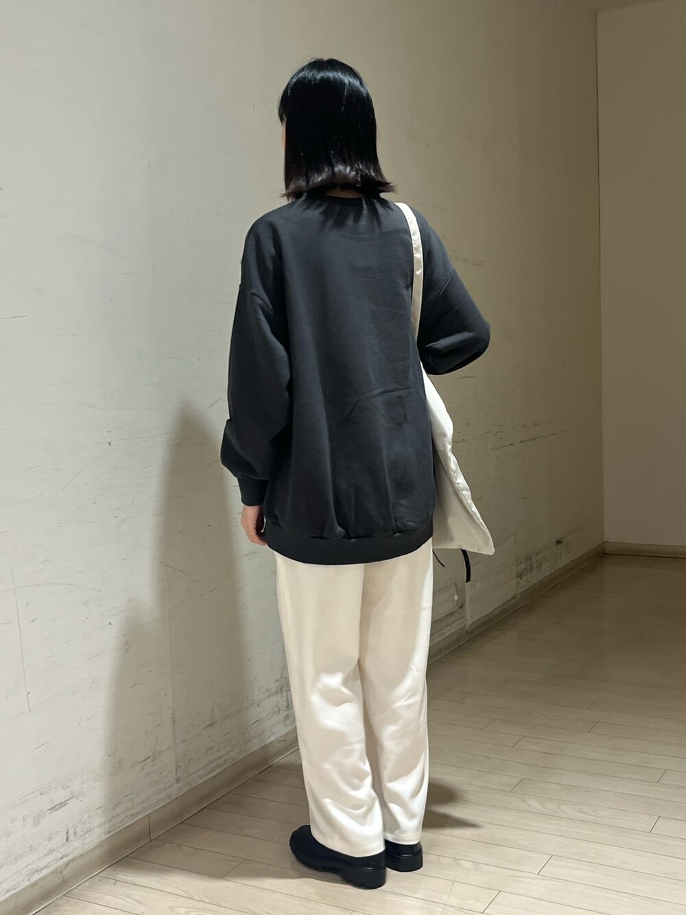 グレー系のTシャツ/カットソー、ベージュ系のハンドバッグ、ホワイト系のその他パンツを着用したレディースの秋コーディネートの2枚目の写真