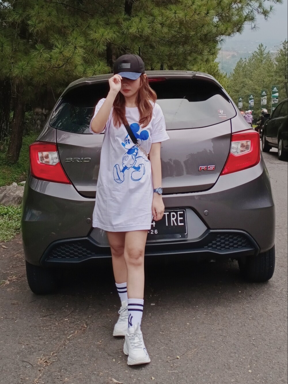 ホワイト系のシャツワンピース、ブラック系のショルダーバッグ、ホワイト系のスニーカーを着用したレディースの春コーディネートの3枚目の写真