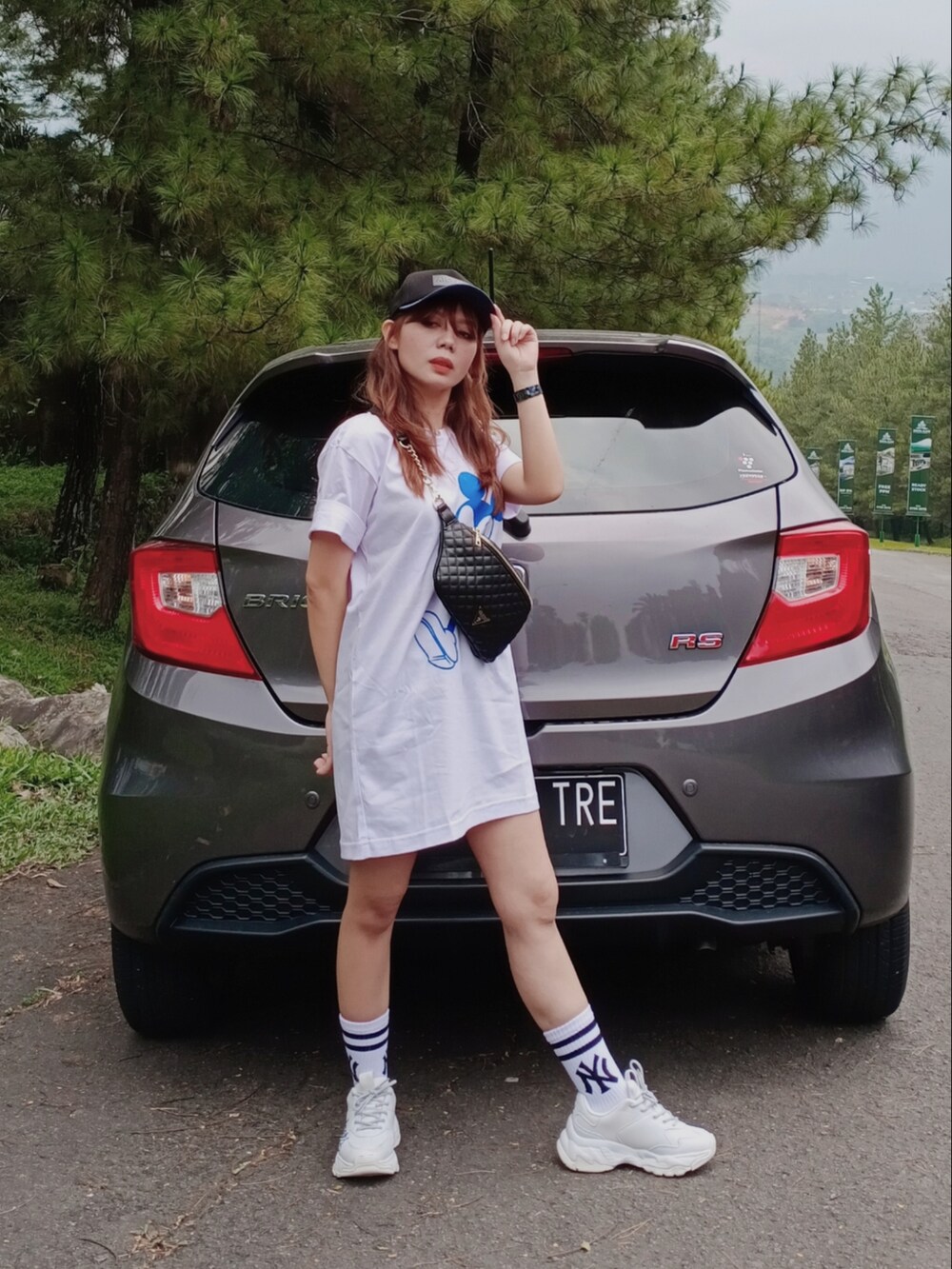 ホワイト系のシャツワンピース、ブラック系のショルダーバッグ、ホワイト系のスニーカーを着用したレディースの春コーディネートの2枚目の写真