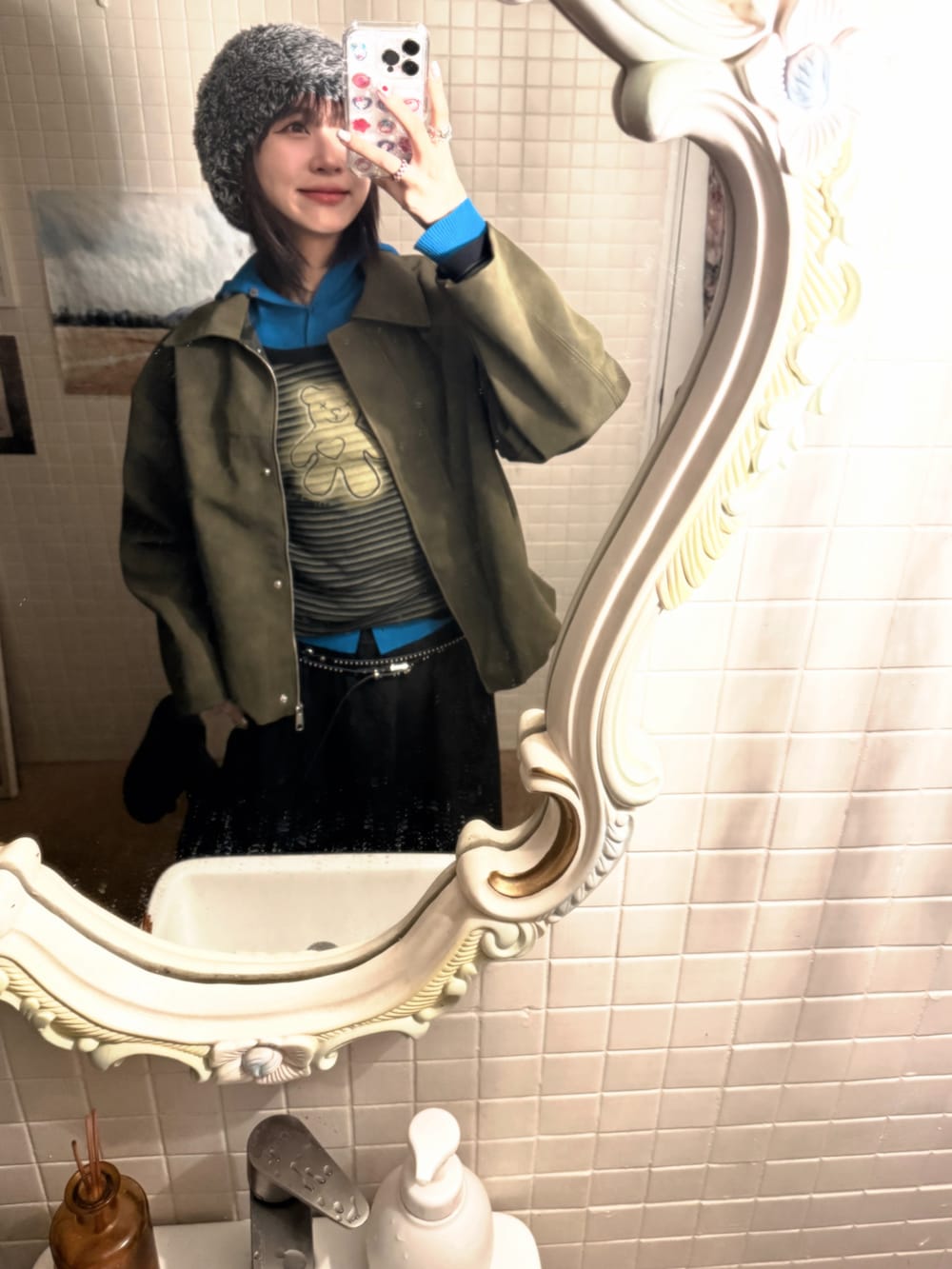 ブラック系のスニーカー、ブルー系のニット/セーター、グリーン系のTシャツ/カットソーを着用したレディースの春コーディネートの2枚目の写真