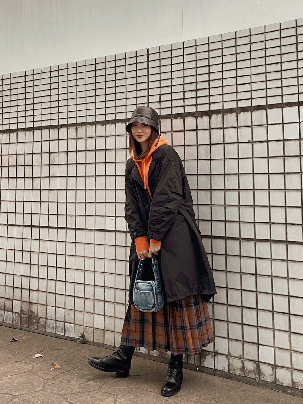 オレンジ系のニット/セーター、ブラック系のその他アウター、ブラウン系のスカートを着用したレディースの冬コーディネートの4枚目の写真