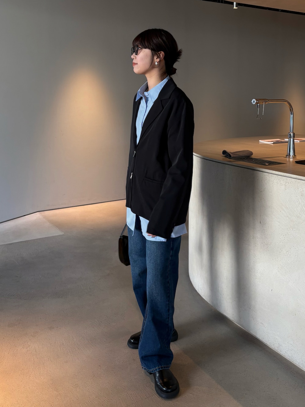 ブルー系のデニムパンツ、ブルー系のシャツ/ブラウス、ブラック系のテーラードジャケットを着用したレディースの春コーディネートの2枚目の写真