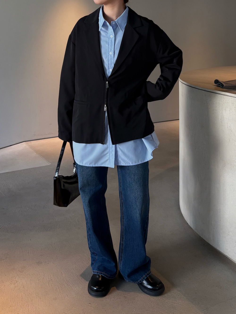 ブルー系のデニムパンツ、ブルー系のシャツ/ブラウス、ブラック系のテーラードジャケットを着用したレディースの春コーディネートの3枚目の写真