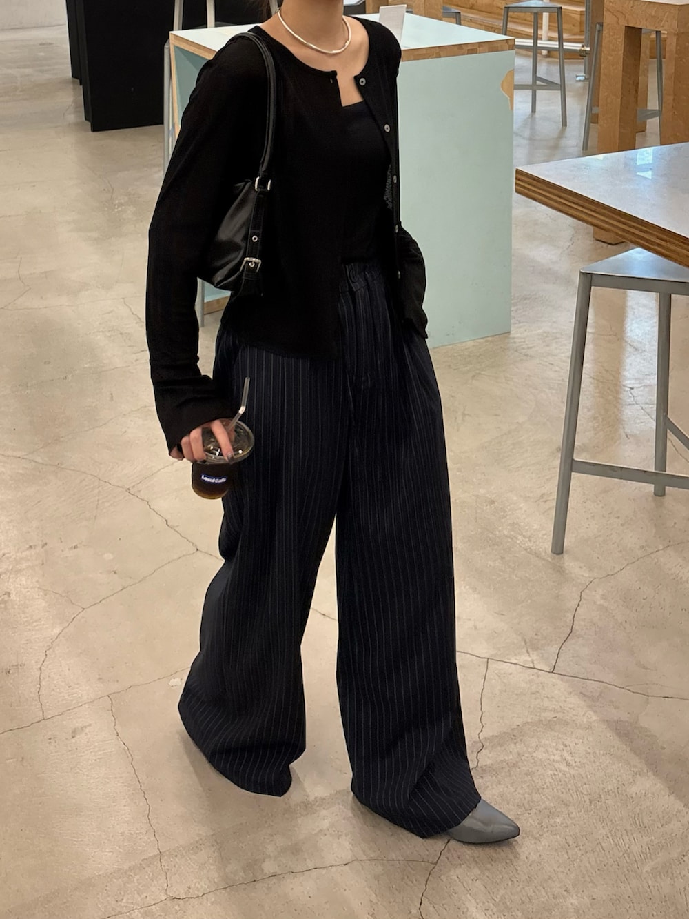 ブルー系のスラックス、ブラック系のカーディガン/ボレロを着用したレディースの秋コーディネートの2枚目の写真