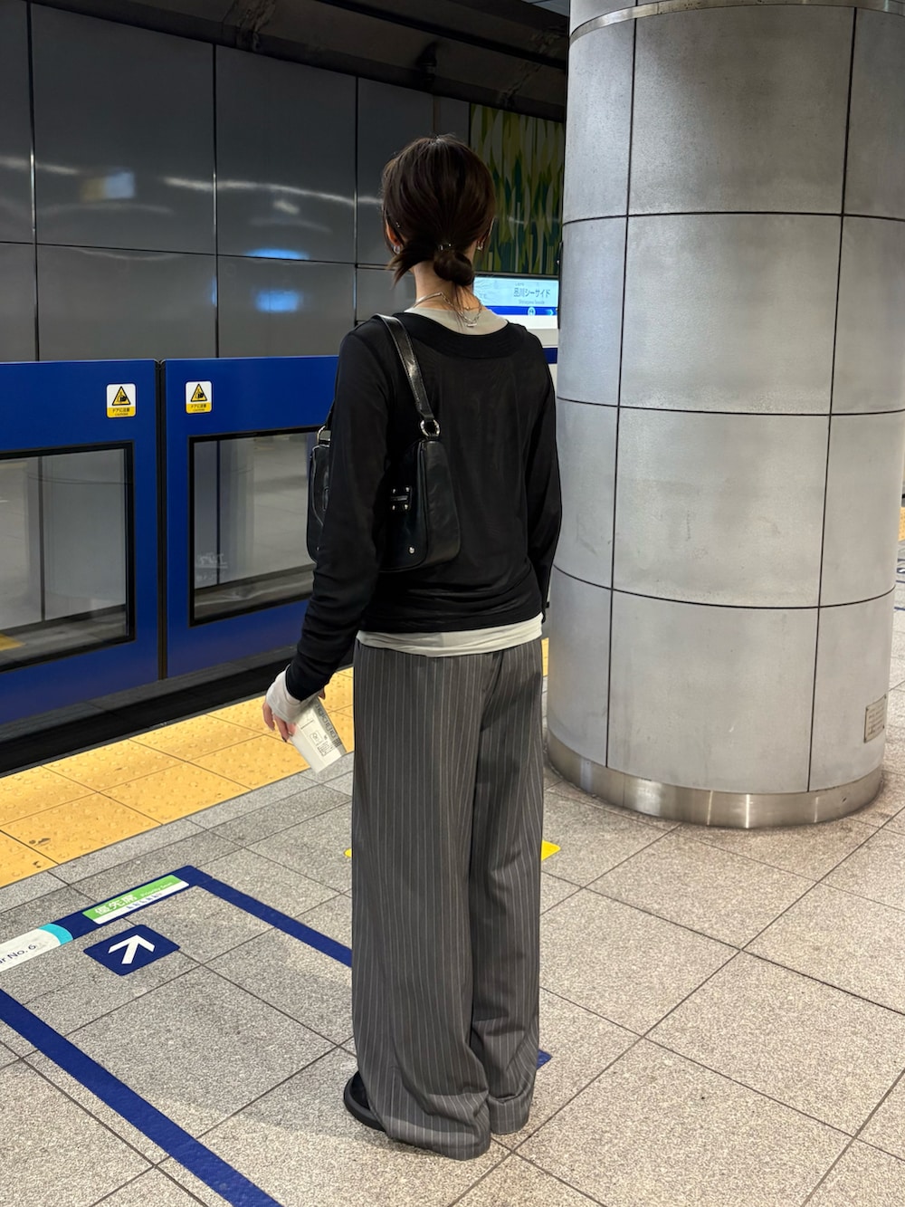 グレー系のスラックス、ブラック系のTシャツ/カットソーを着用したレディースの秋コーディネートの2枚目の写真