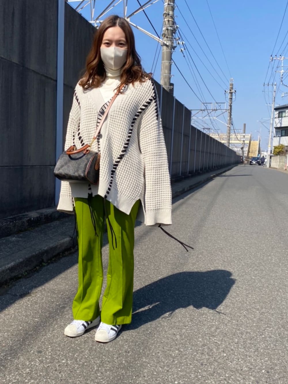 ブラウン系のバッグ、ホワイト系のカーディガン/ボレロ、グリーン系のその他パンツを着用したレディースの春コーディネートの2枚目の写真