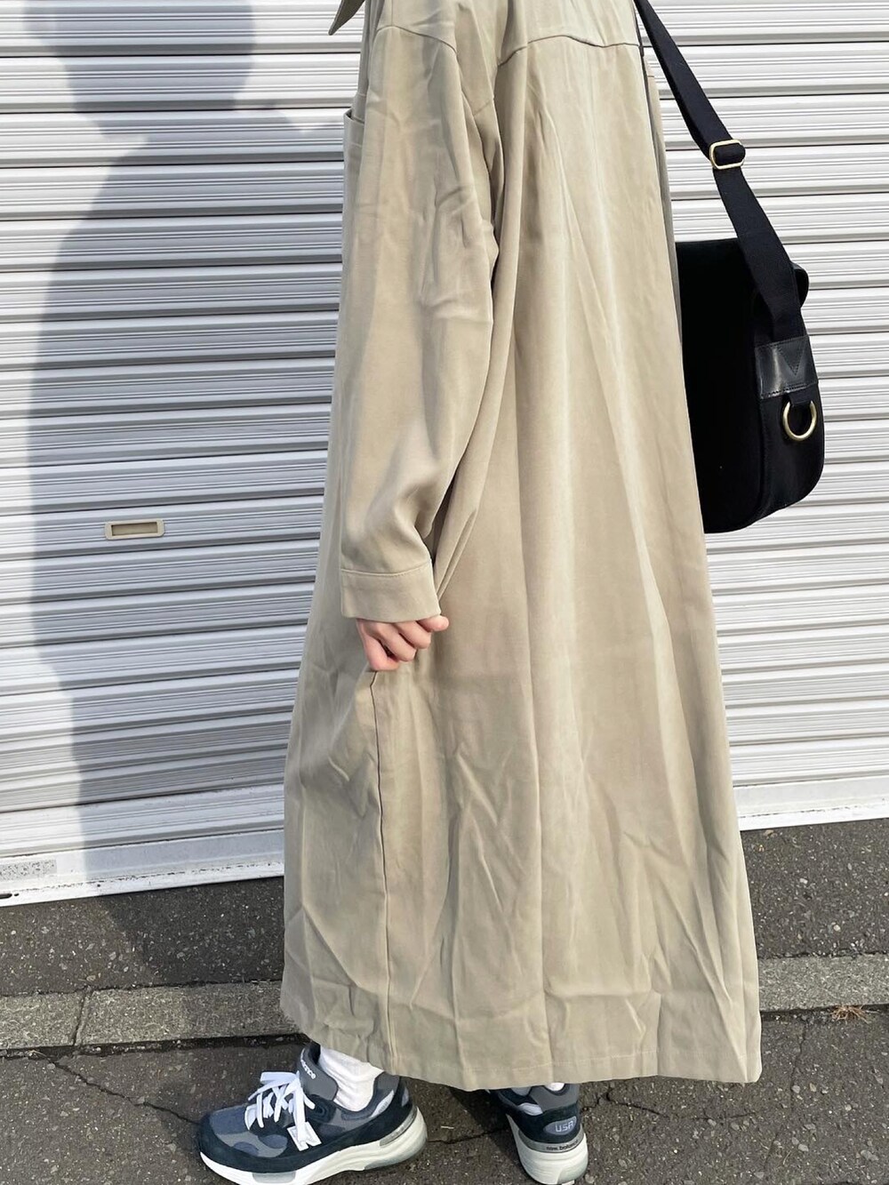 ブラック系のショルダーバッグ、ブルー系のスニーカーを着用したレディースの秋コーディネートの3枚目の写真