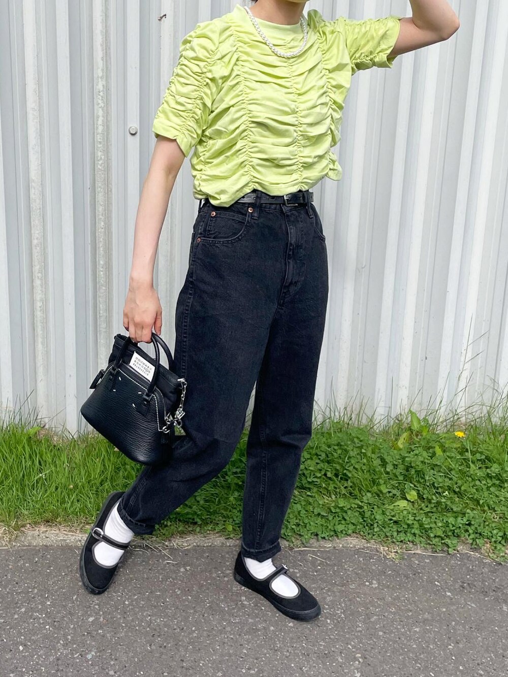 ブラック系のデニムパンツ、グリーン系のトップス、ブラック系のバレエシューズを着用したレディースの夏コーディネートの2枚目の写真
