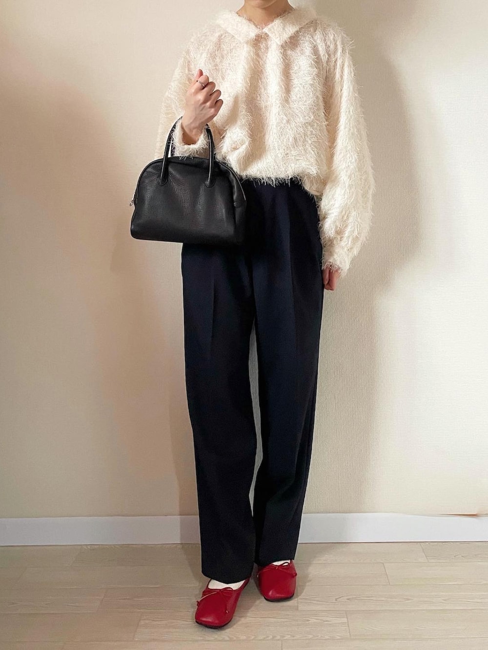 ホワイト系のトップス、ブラック系のボストンバッグ、ブルー系のスラックスを着用したレディースの秋コーディネートの3枚目の写真