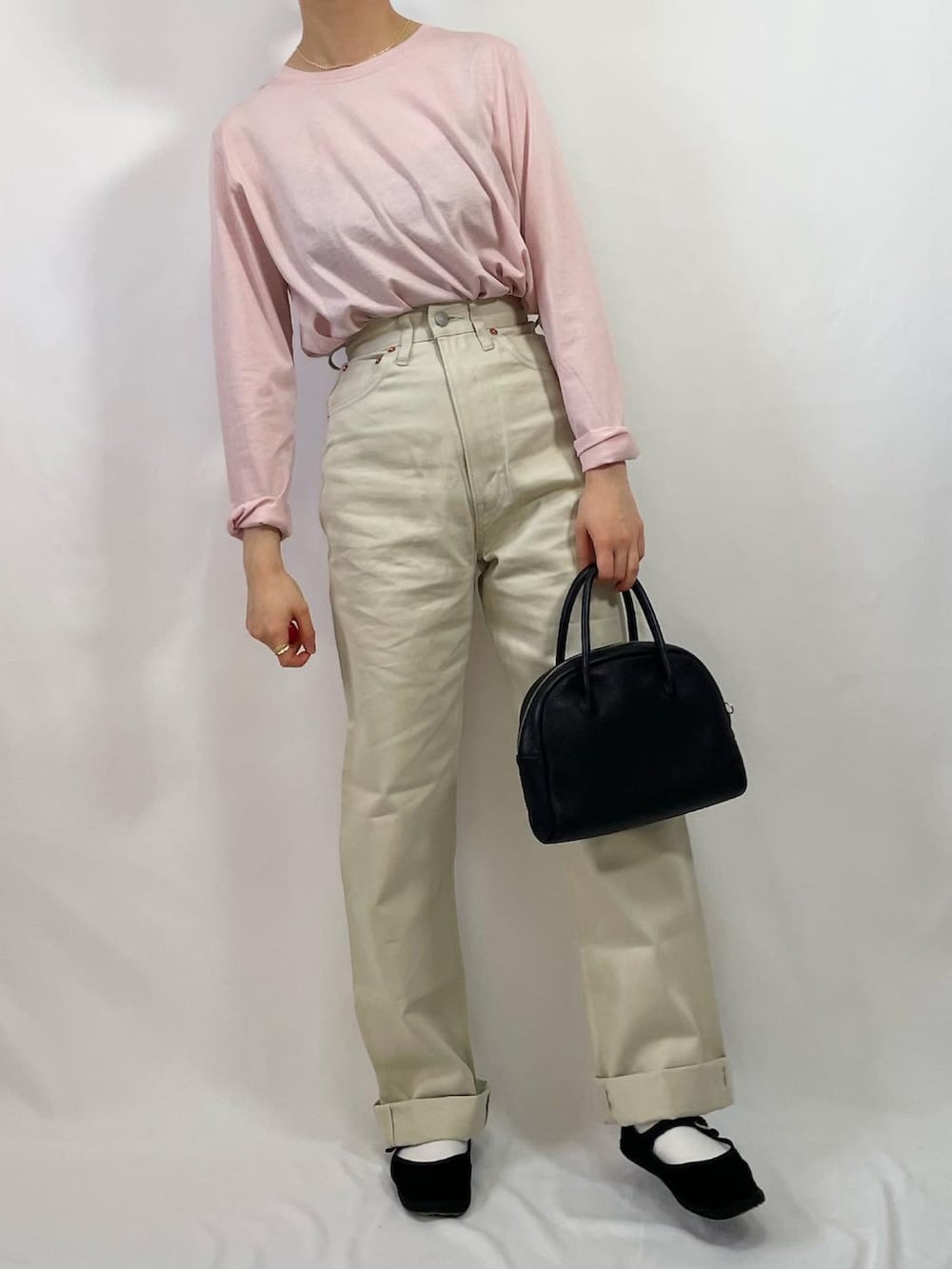 ホワイト系のデニムパンツ、ブラック系のその他シューズ、ブラック系のボストンバッグを着用したレディースの冬コーディネートの3枚目の写真