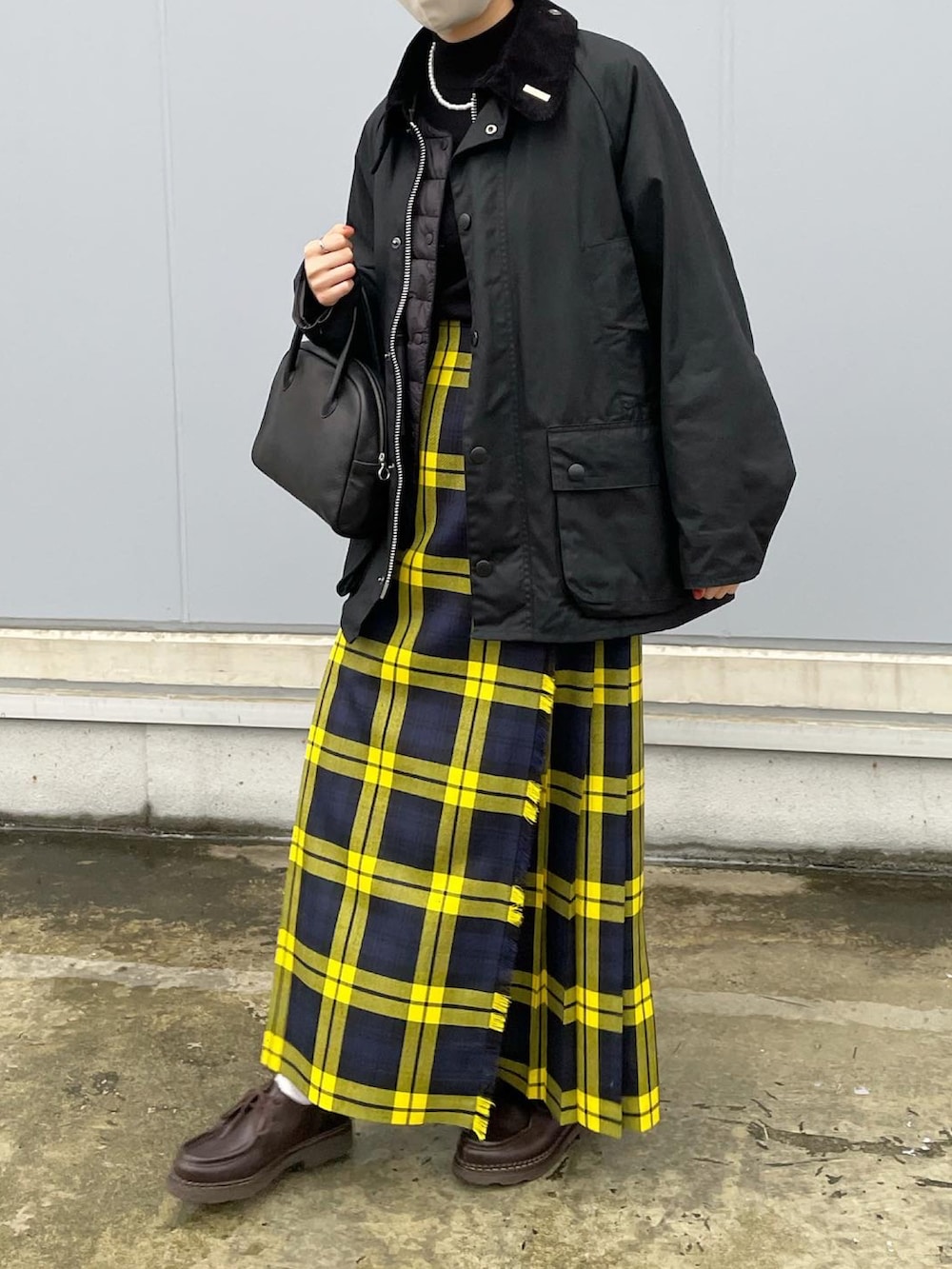 ブラック系のニット/セーター、イエロー系のスカート、ブラウン系のドレスシューズを着用したレディースの秋コーディネートの4枚目の写真