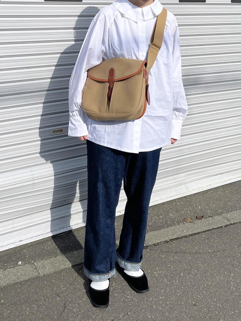 グリーン系のショルダーバッグ、ブルー系のデニムパンツ、ブラック系のその他シューズを着用したレディースの秋コーディネートの2枚目の写真