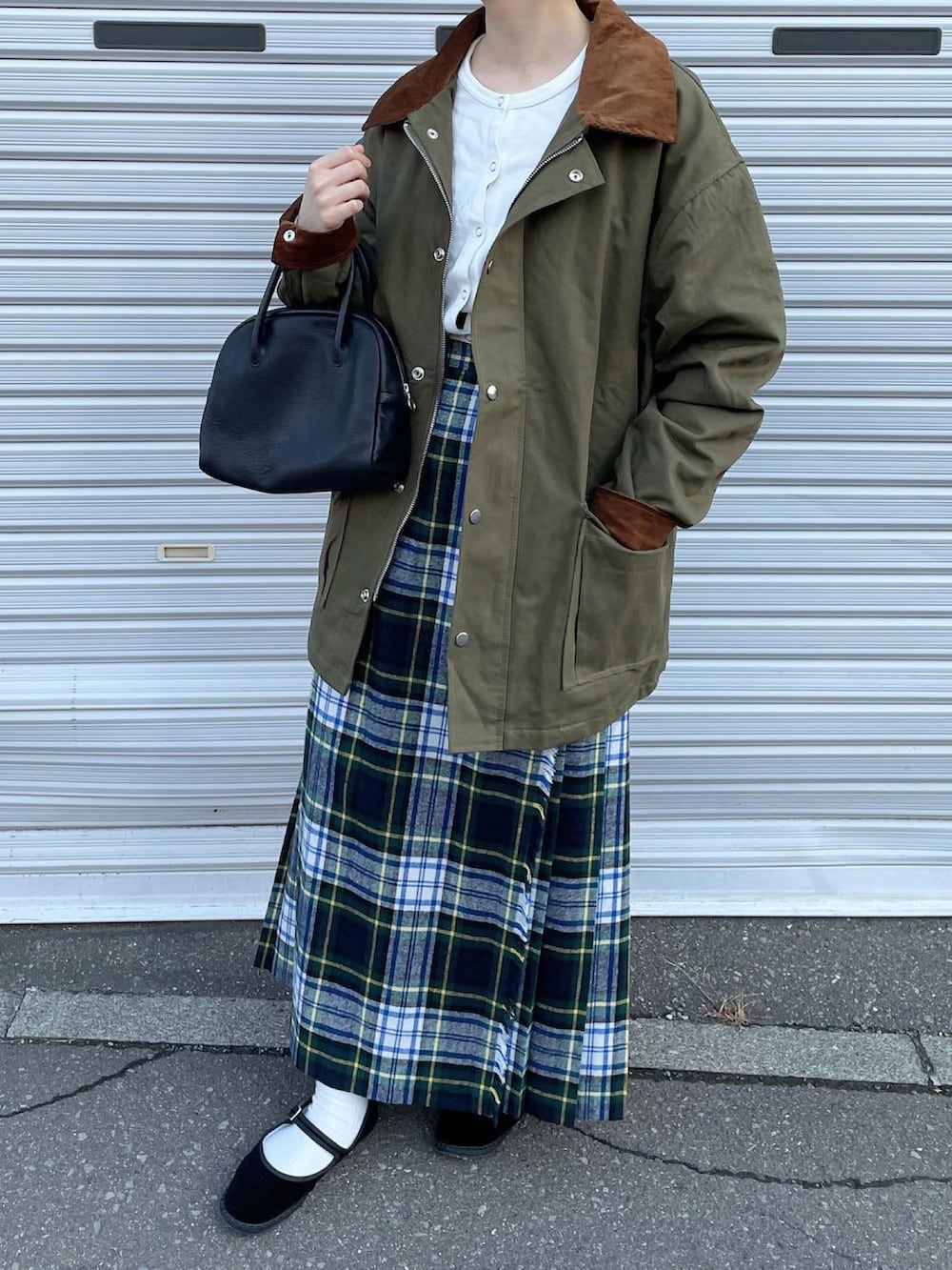 ホワイト系のカーディガン/ボレロ、グリーン系のスカート、ブラック系のボストンバッグを着用したレディースの秋コーディネートの2枚目の写真