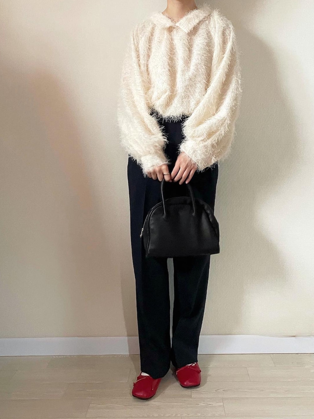 ホワイト系のトップス、ブラック系のボストンバッグ、ブルー系のスラックスを着用したレディースの秋コーディネートの2枚目の写真