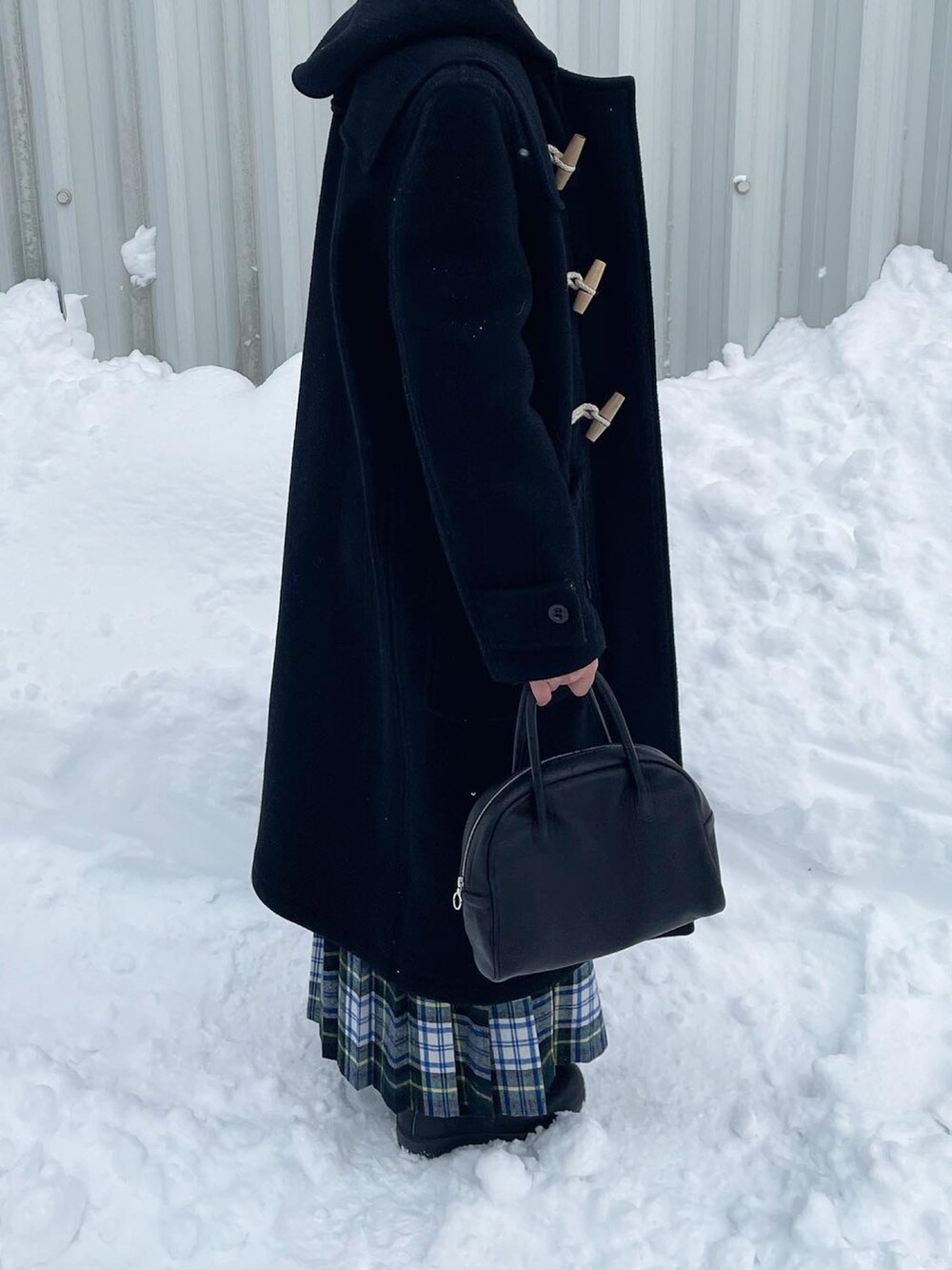 ブルー系のニット/セーター、ブラック系のボストンバッグ、グリーン系のスカートを着用したレディースの冬コーディネートの4枚目の写真
