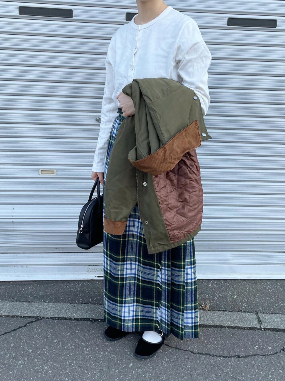 ホワイト系のカーディガン/ボレロ、グリーン系のスカート、ブラック系のボストンバッグを着用したレディースの秋コーディネートの3枚目の写真