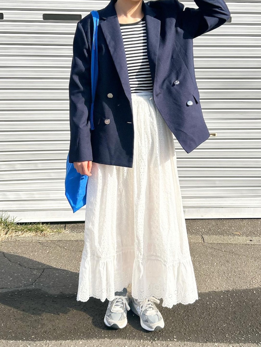 ブルー系のトートバッグ、グレー系のスニーカー、ブルー系のジャケット/アウターを着用したレディースの春コーディネートの3枚目の写真