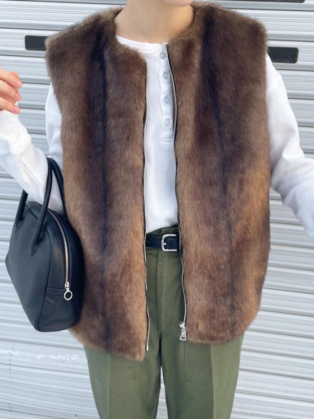 グリーン系のパンツ、ブラック系のボストンバッグ、グレー系のスニーカーを着用したレディースの冬コーディネートの4枚目の写真