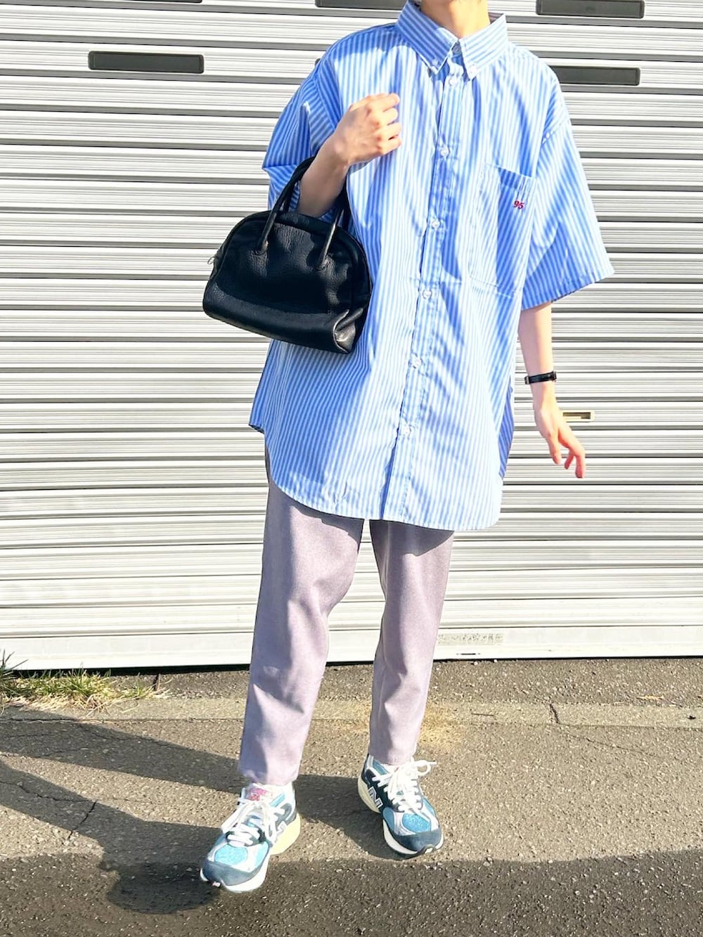 ブルー系のシャツ/ブラウス、ブラック系のボストンバッグ、ブルー系のスニーカーを着用したレディースの春コーディネートの2枚目の写真