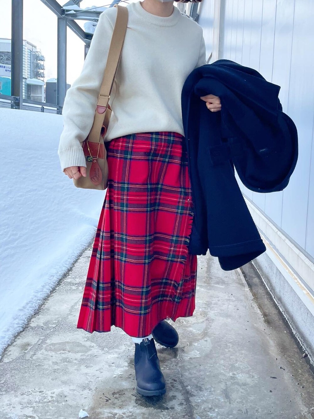 ベージュ系のショルダーバッグ、ブラック系のダッフルコート、レッド系のスカートを着用したレディースの冬コーディネートの3枚目の写真