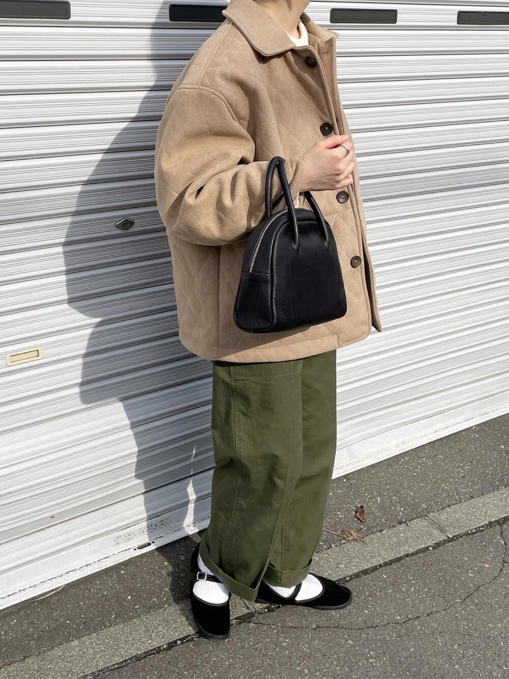 グリーン系のパンツ、ブラック系のボストンバッグを着用したレディースの秋コーディネートの2枚目の写真