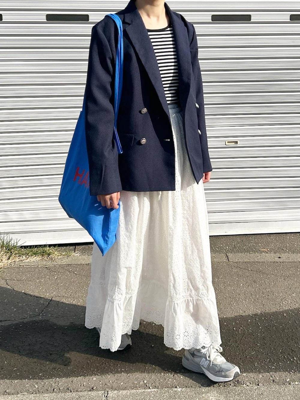 ブルー系のトートバッグ、グレー系のスニーカー、ブルー系のジャケット/アウターを着用したレディースの春コーディネートの2枚目の写真