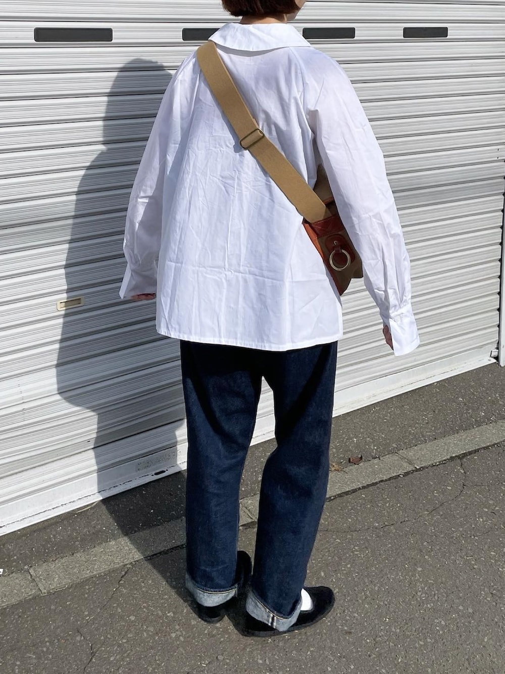 グリーン系のショルダーバッグ、ブルー系のデニムパンツ、ブラック系のその他シューズを着用したレディースの秋コーディネートの3枚目の写真