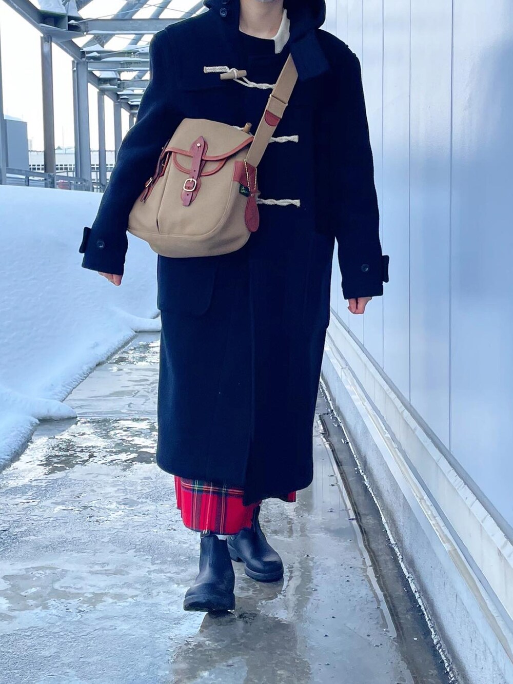 ベージュ系のショルダーバッグ、ブラック系のダッフルコート、レッド系のスカートを着用したレディースの冬コーディネートの4枚目の写真