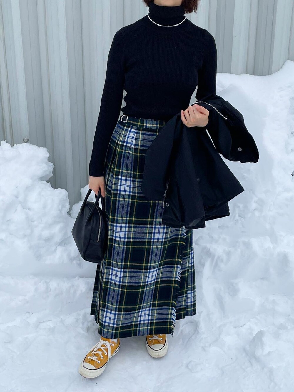 ブラック系のボストンバッグ、ブラック系のブルゾン、イエロー系のスニーカーを着用したレディースの冬コーディネートの3枚目の写真