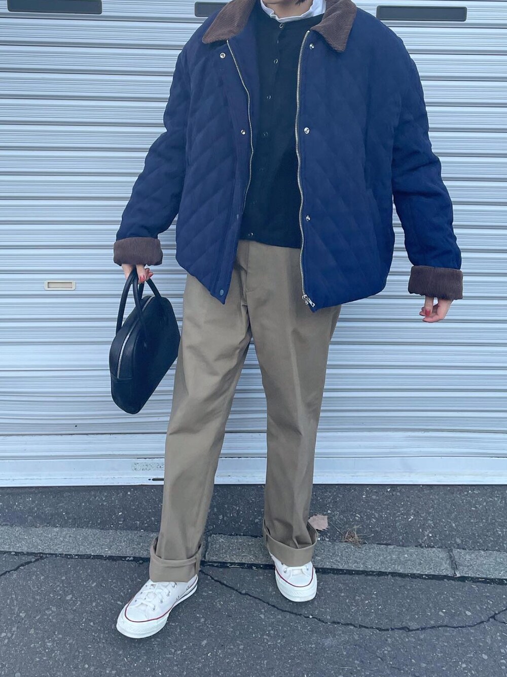 ベージュ系のチノパンツ、ホワイト系のスニーカー、ブラック系のボストンバッグを着用したレディースの冬コーディネートの4枚目の写真