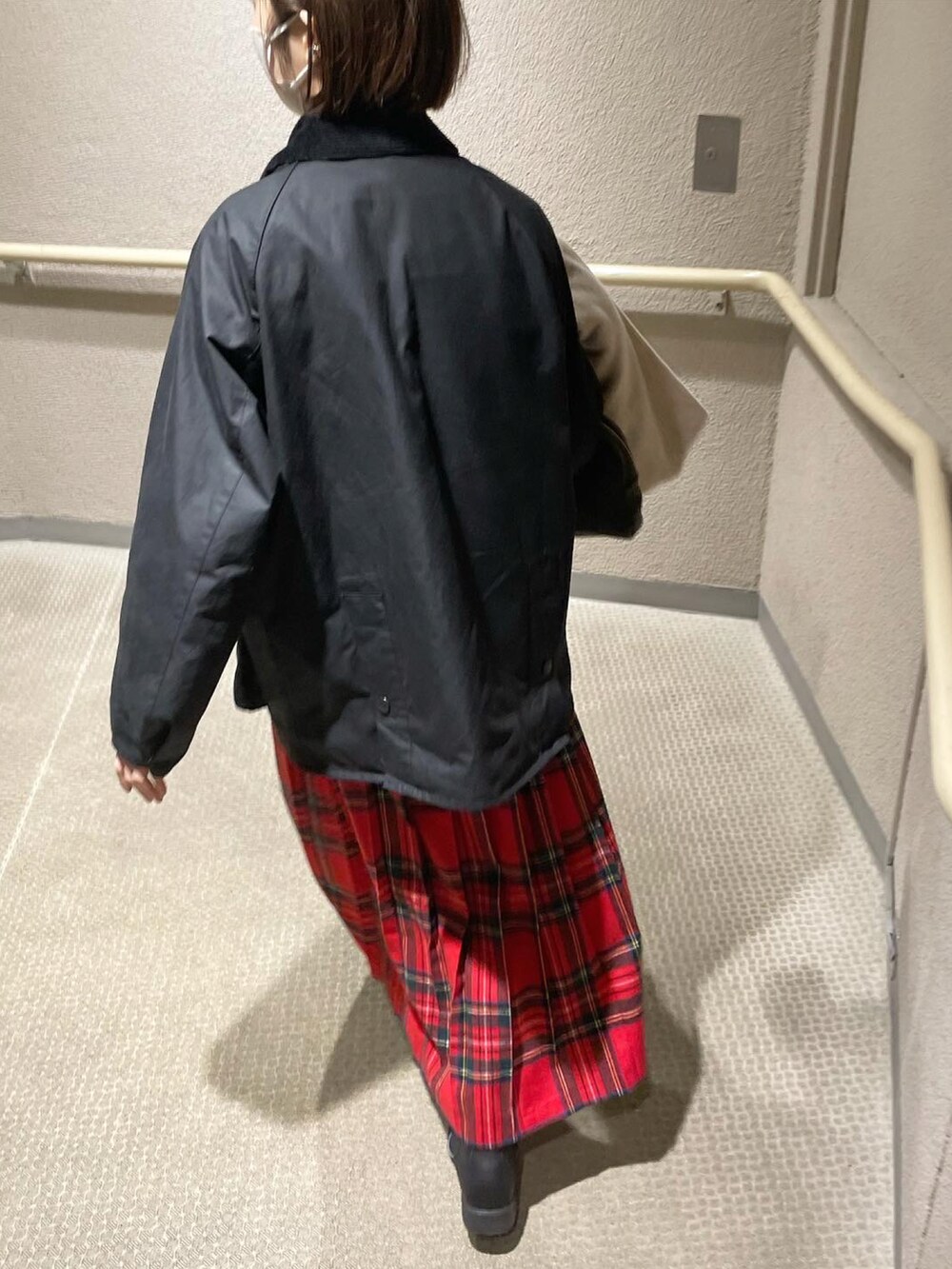 ブラック系のブルゾン、レッド系のスカート、ブラック系のブーツを着用したレディースの冬コーディネートの5枚目の写真