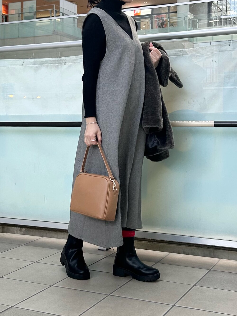 グレー系のその他アウター、グレー系のワンピース、ベージュ系のショルダーバッグを着用したレディースの冬コーディネートの5枚目の写真