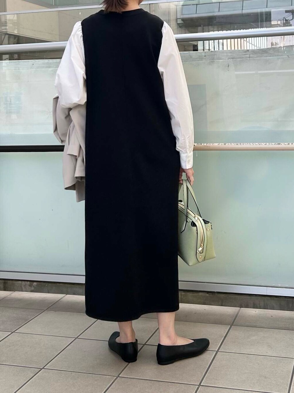 ブラック系のパンプス、ベージュ系のその他アウター、ブラック系のワンピースを着用したレディースの春コーディネートの6枚目の写真