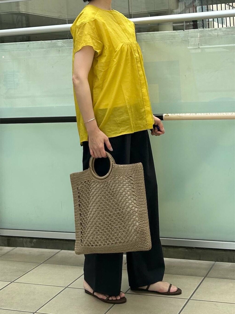 ブルー系のその他パンツ、ブラウン系のサンダル、イエロー系のシャツ/ブラウスを着用したレディースの夏コーディネートの2枚目の写真