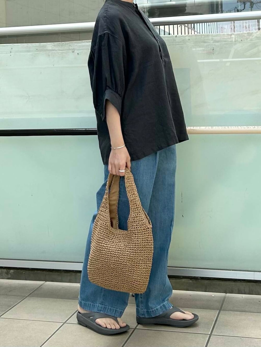 イエロー系のトートバッグ、グレー系のシャツ/ブラウス、グレー系のサンダルを着用したレディースの春コーディネートの2枚目の写真