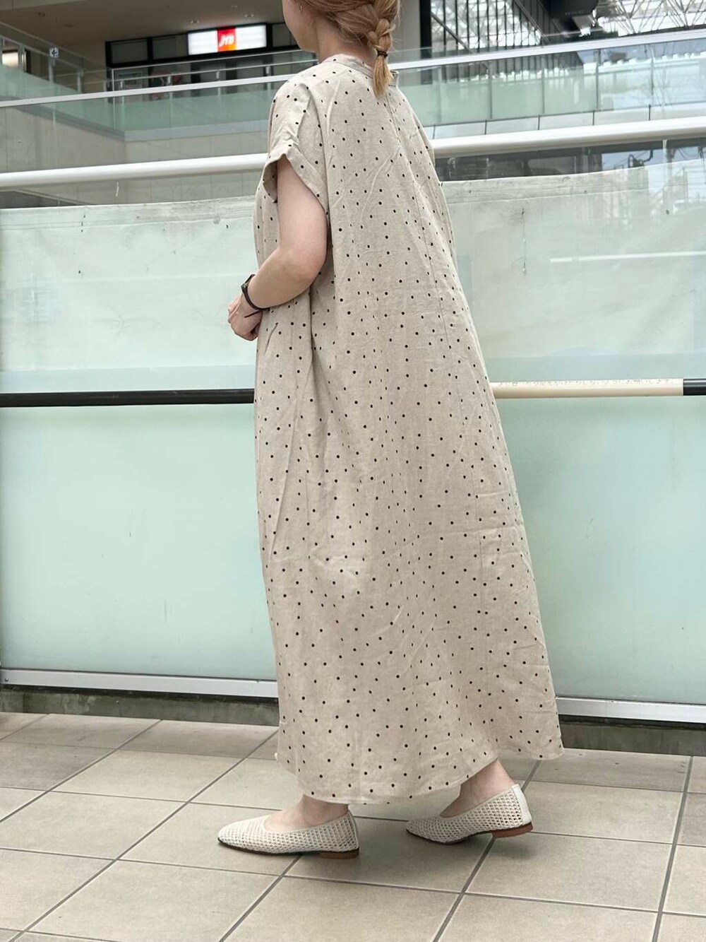 レッド系のトートバッグ、ホワイト系のバレエシューズ、ベージュ系のワンピースを着用したレディースの夏コーディネートの3枚目の写真