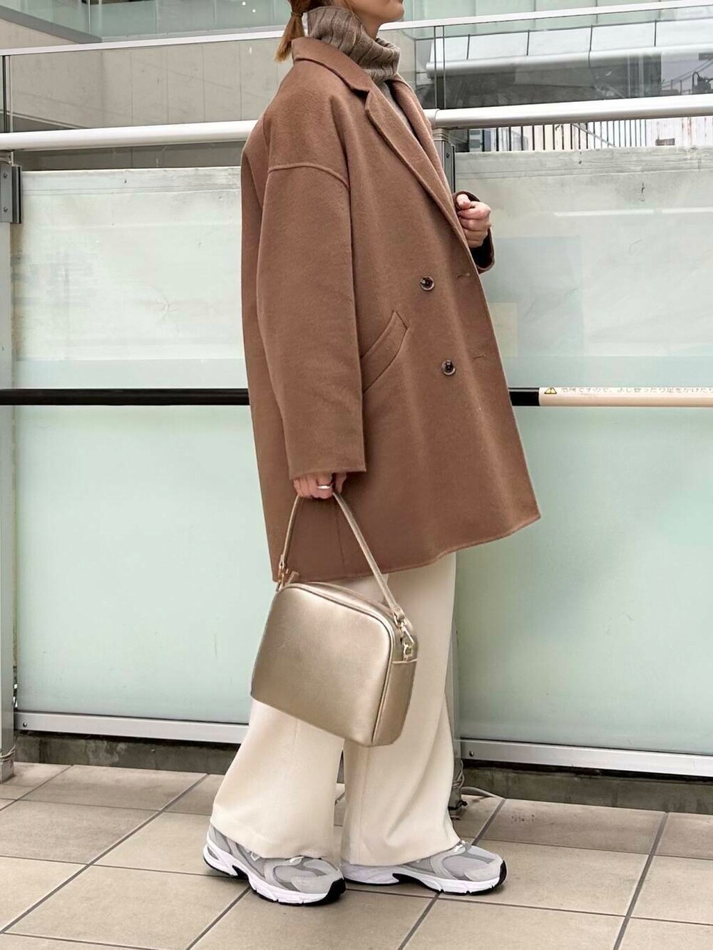 ブラウン系のその他アウター、ゴールド系のショルダーバッグ、ホワイト系のニット/セーターを着用したレディースの秋コーディネートの2枚目の写真