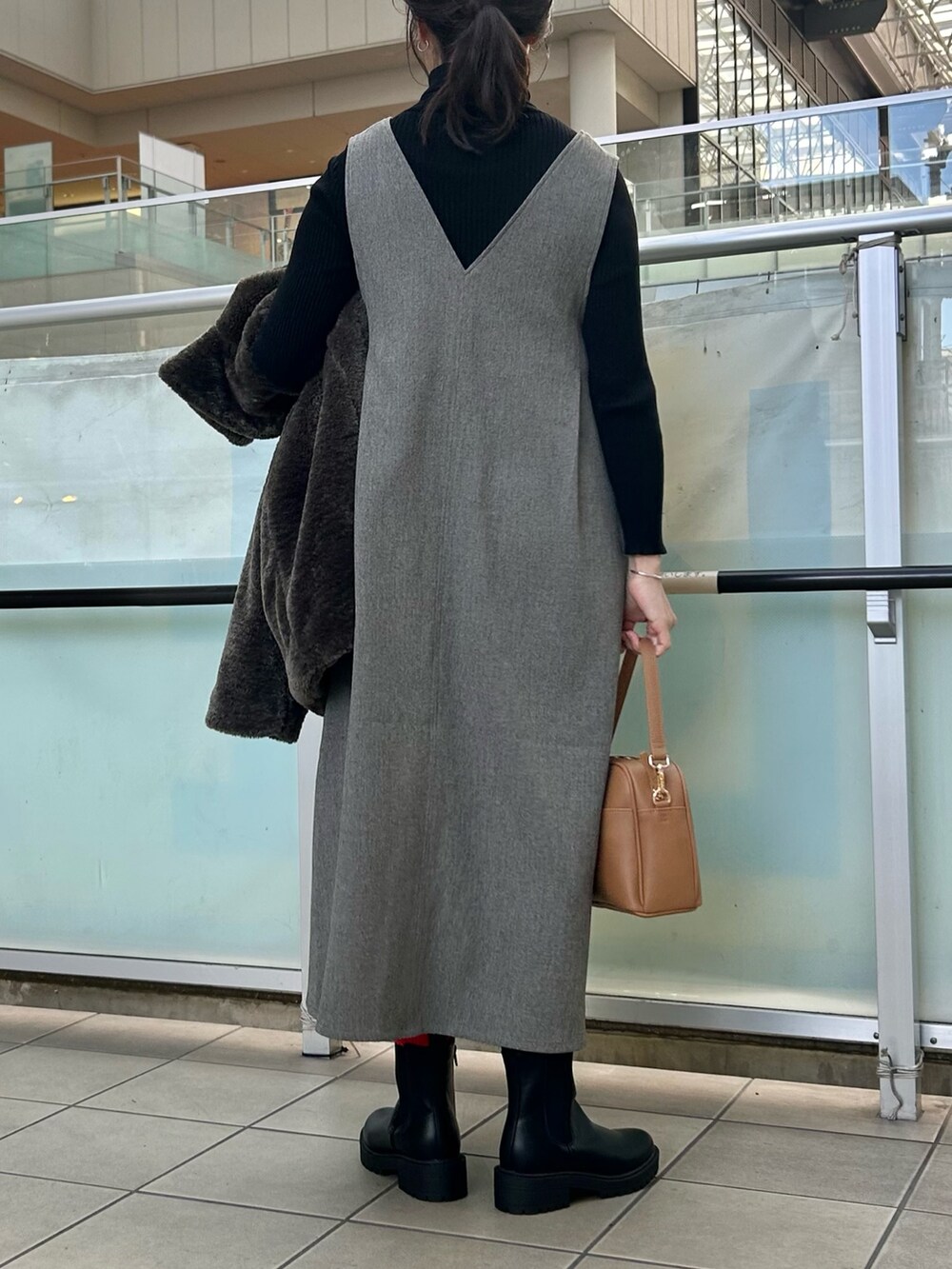 グレー系のその他アウター、グレー系のワンピース、ベージュ系のショルダーバッグを着用したレディースの冬コーディネートの6枚目の写真