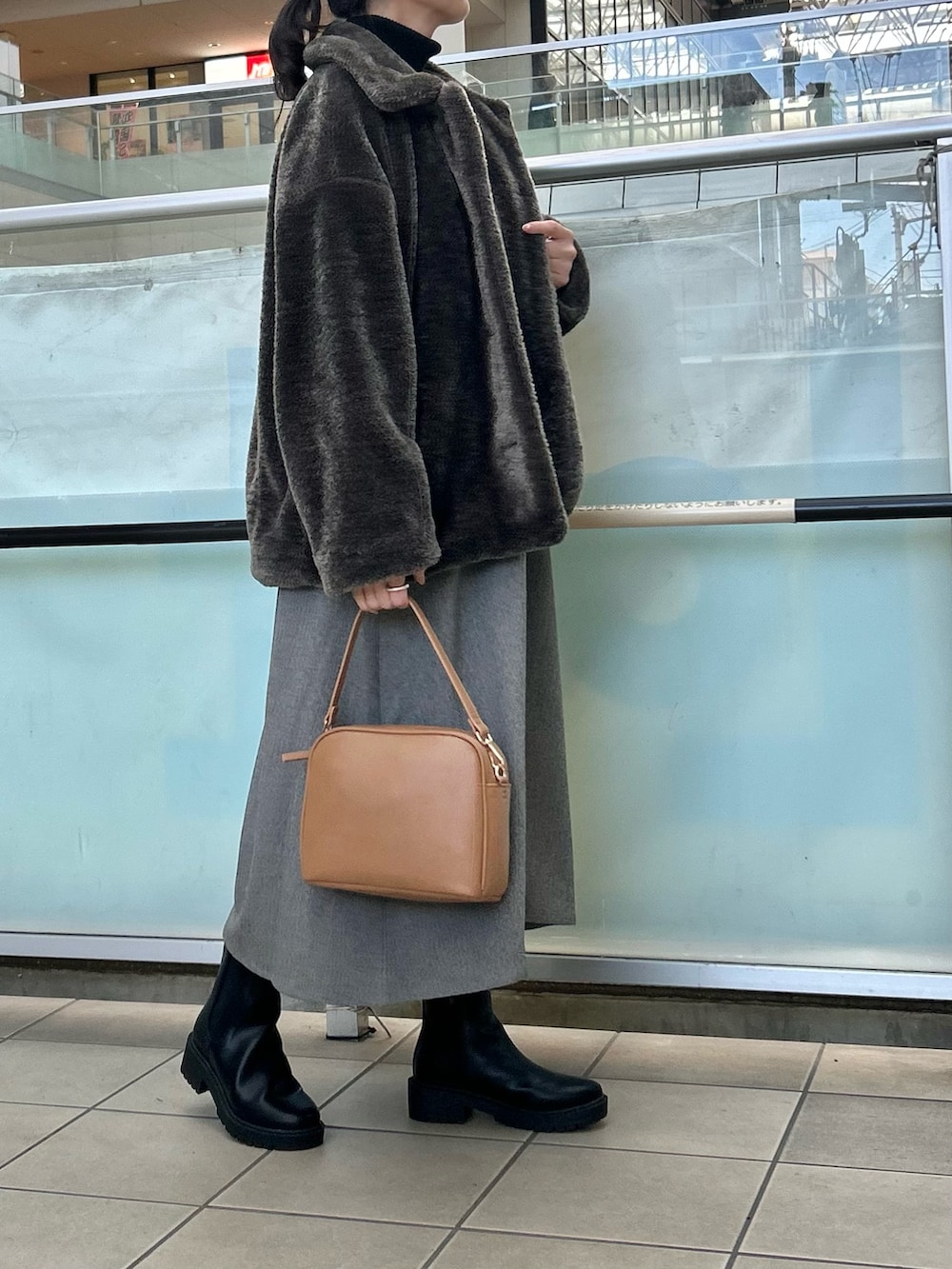 グレー系のその他アウター、グレー系のワンピース、ベージュ系のショルダーバッグを着用したレディースの冬コーディネートの2枚目の写真