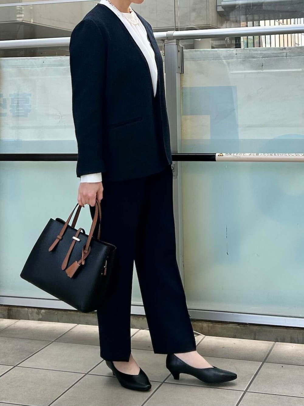 ブラック系のトートバッグ、ブルー系のスーツジャケット、ホワイト系のシャツ/ブラウスを着用したレディースの冬コーディネートの2枚目の写真