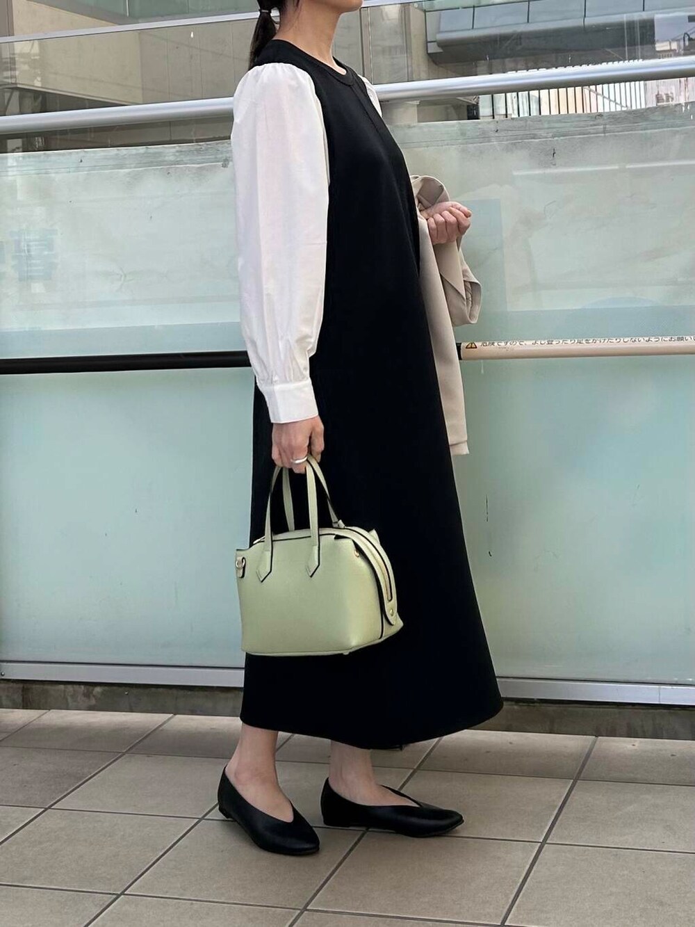 ブラック系のパンプス、ベージュ系のその他アウター、ブラック系のワンピースを着用したレディースの春コーディネートの5枚目の写真