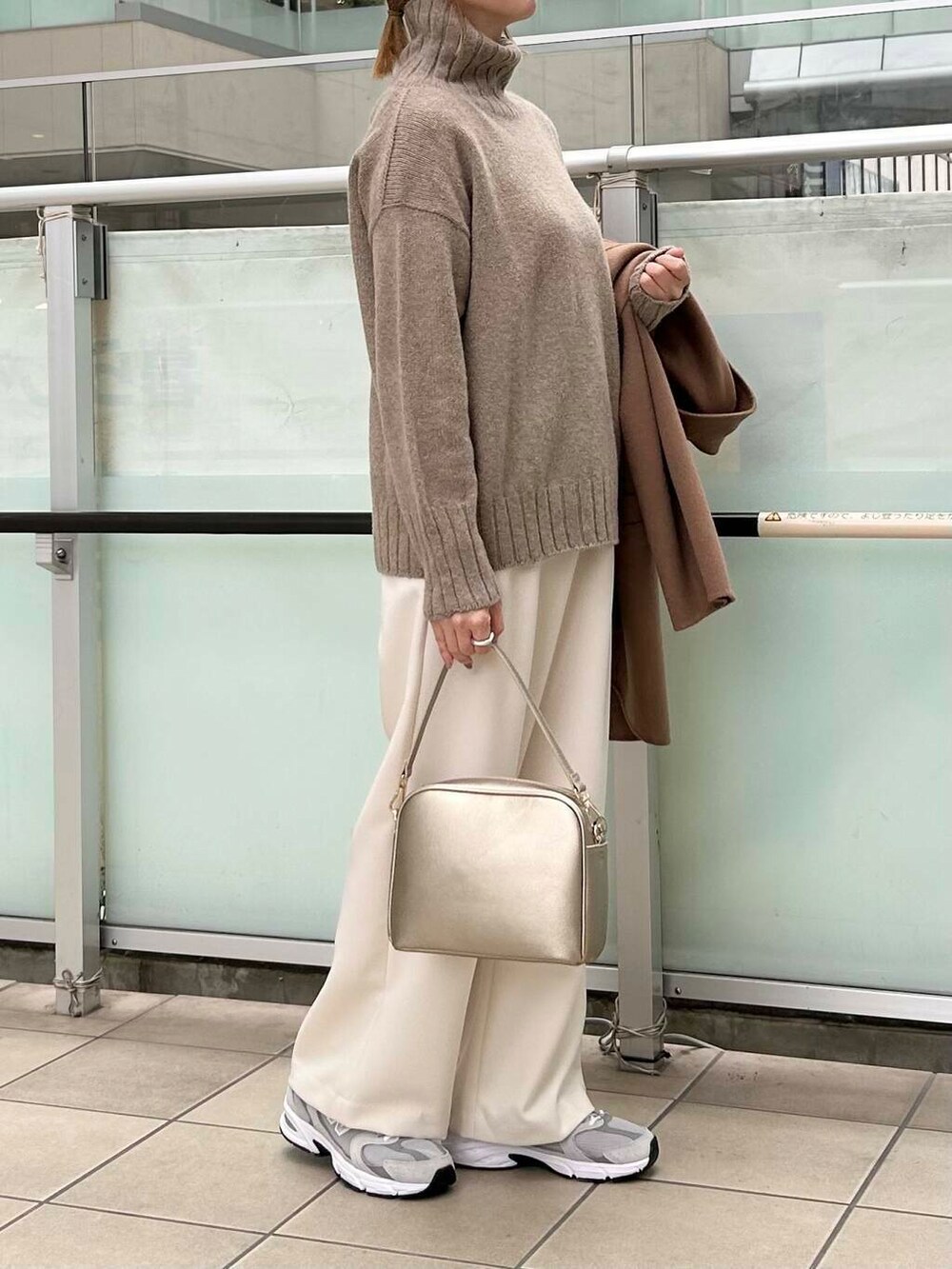 ブラウン系のその他アウター、ゴールド系のショルダーバッグ、ホワイト系のニット/セーターを着用したレディースの秋コーディネートの6枚目の写真